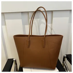Close-up of brown litchi pattern leather tote with Genuine Leather embossed detail