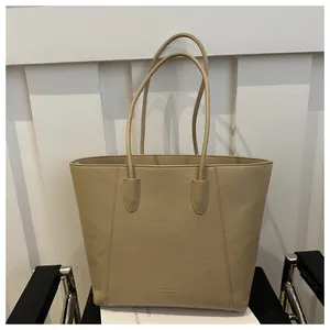 Detailed macro view of the premium litchi grain leather texture on beige tote bag