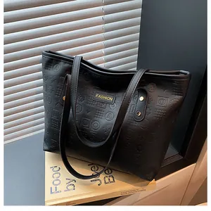 Detail of black tote bag featuring embossed geometric patterns and gold fashion logo