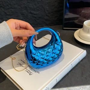 Electric blue quilted acrylic clutch handbag with a round handle and gold chain