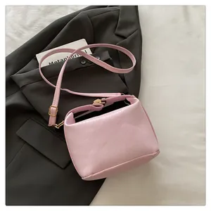 Detailed macro view of pink vertical textured leather bag with elegant gold hardware buckles