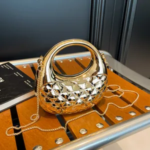 Elegant gold acrylic lattice clutch evening bag with metal chain on wooden bench