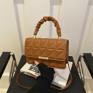 Quilted caramel brown crossbody bag with ruched handle and golden metal clasp