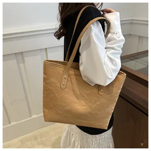 Detail of vintage tote bag showing wrinkled paper texture and golden rivets on the side