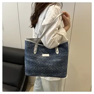 Détail d'un sac cabas en denim bleu à pois avec bandoulières en cuir argenté et rivets