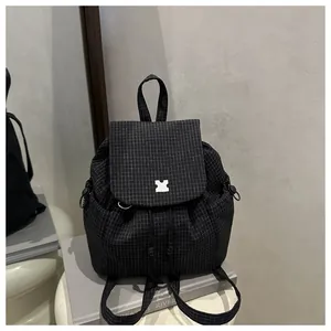 Close-up of black grid texture drawstring backpack with white buckle detail