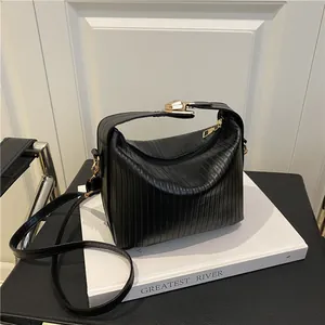 Fashionable black pleated tote bag for women with gold hardware and crossbody strap