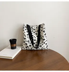 Close-up of floral canvas tote bag featuring white lace trim on a vintage wooden table