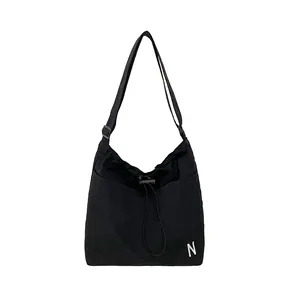 Lightweight black drawstring crossbody bag with white N logo for casual commuting
