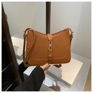 Detailed view of brown leather bag with metallic ring buckle and fine stitching details