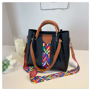 Dettaglio borsa tote in pelle nera con tracolla in tessuto geometrico colorato