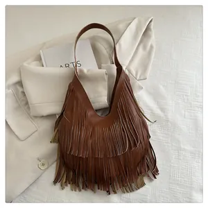 Detail einer karamellbraunen Schultertasche mit mehrlagigen Fransen im Boho-Stil