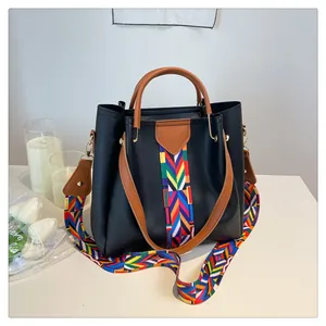 Dettaglio della borsa tote nera in pelle martellata con tracolla etnica intrecciata e manici