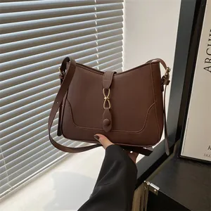Minimalist dark brown matte leather shoulder bag with golden buckle and adjustable strap
