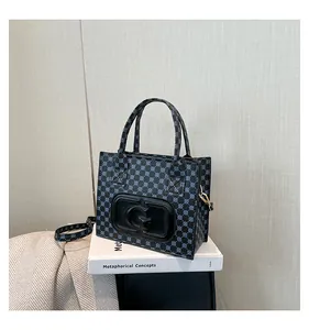 Detail of printed crossbody bag showing G logo, textured leather, and golden hardware