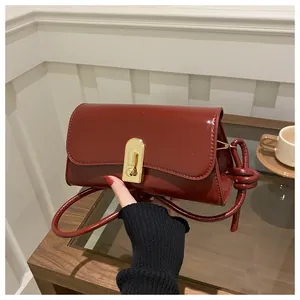 Close-up of the vintage dark red leather handbag featuring a golden semi-circular lock buckle