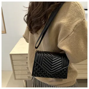 Detail van zwarte gewatteerde crossbodytas met dubbele stiksels en brede schouderriem