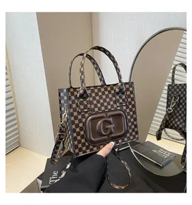 Macro shot of vintage tote bag with embossed G logo and elegant monogram pattern