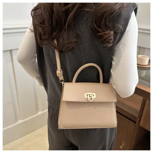 Detail der minimalistischen beigen Handtasche mit feiner Lederstruktur und Goldverschluss