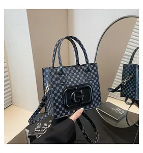 Detail shot of the vintage geometric pattern and luxury G logo on the crossbody tote bag