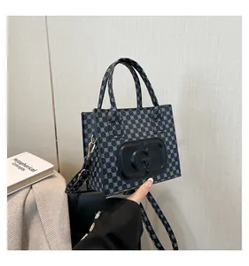 Close-up of structured rectangular tote bag with blue geometric pattern and G logo