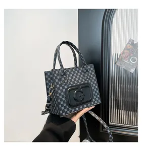 Detail of printed crossbody bag featuring G logo hardware and blue geometric pattern