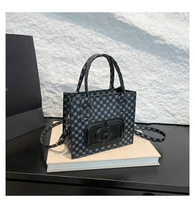 Detail showing geometric printed bag with embossed letter G and textured carry handles
