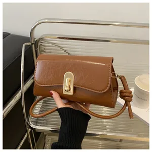 Close-up of caramel vintage baguette bag featuring glossy leather and golden metal clasp