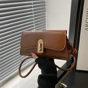 Vintage caramel brown leather baguette bag with gold buckle and textured finish
