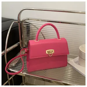 Detail der rosapinkfarbenen Handtasche mit Goldschloss und elegantem Zylindergriff
