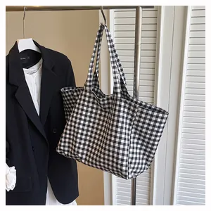 Détail d'un grand sac cabas en toile à damier noir et blanc sur un cintre élégant