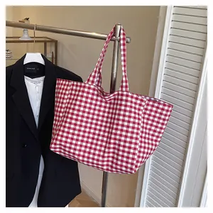 Détail du sac cabas en toile à carreaux vichy rouge et blanc avec de larges poignées