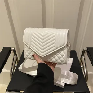 Chique witte gewatteerde crossbodytas met brede stoffen riem in een moderne lifestyle-setting
