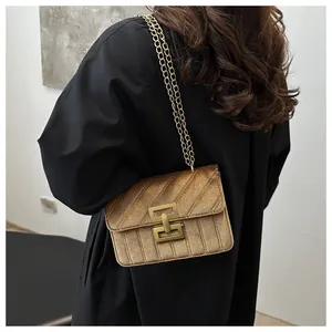 Detail of golden quilted velvet texture and chain strap on a vintage square crossbody bag