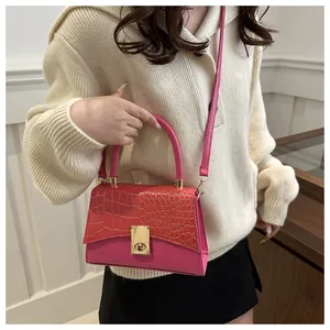 Detailaufnahme der pinkfarbenen Kunstledertasche mit Krokoprägung und goldenem Drehverschluss