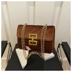 Close-up of vintage brown velvet bag with V-shaped stitching and gold chain strap