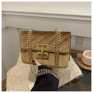 Detailed close-up of golden brown velvet crossbody bag with quilted pattern and gold lock