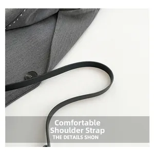 Close-up of gray fabric with white stitching and black leather shoulder strap detail
