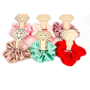Dettaglio del set di 6 elastici scrunchies in raso con confezione in cartone dorato