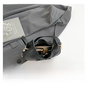 Interior view showing the storage capacity for lipstick and compact in this black leather bag