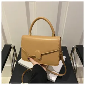 Detailansicht der braunen Lederhandtasche mit goldener ovaler Metallschnalle