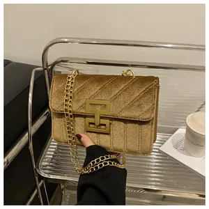 Detail of gold velvet shoulder bag showing quilted texture and metallic chain strap