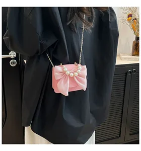 Detail of pink mini bag with large organza bow and elegant pearl handle strap