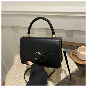 Detail der eleganten schwarzen matten Ledertasche mit goldener Schnalle im Lifestyle
