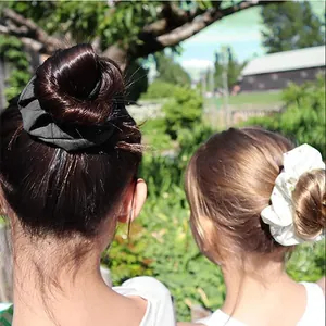 Vista posteriore di elastici in raso neri e bianchi indossati su uno chignon alto