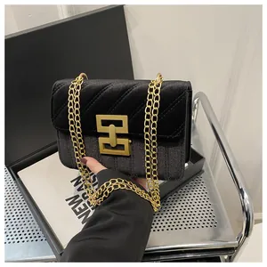 Close-up of black velvet and glitter patchwork crossbody bag with gold buckle