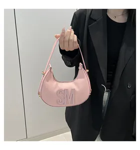 Detailed view of pink leather hobo bag with 3D SM letters and golden hardware