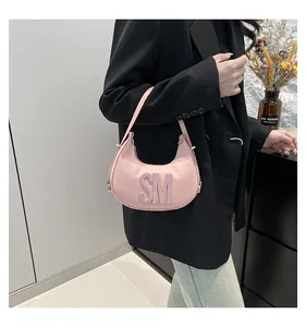 Detail of pink crescent bag with 3D SM letters and textured leather finish