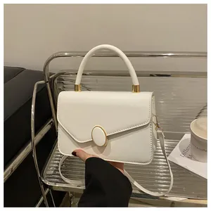 Detailansicht der weißen Handtasche mit strukturiertem Leder und goldenem Verschluss