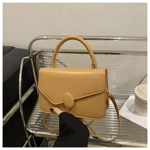 Nahaufnahme hellbraune matte Lederhandtasche mit rundem Verschluss und elegantem Handgriff